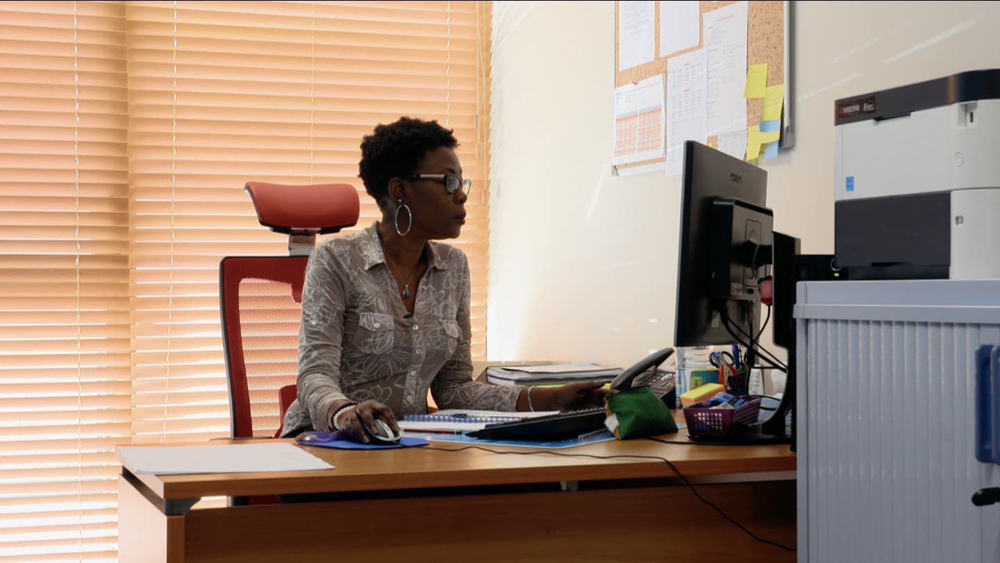 Une femme travaille à son bureau, devant un ordinateur.